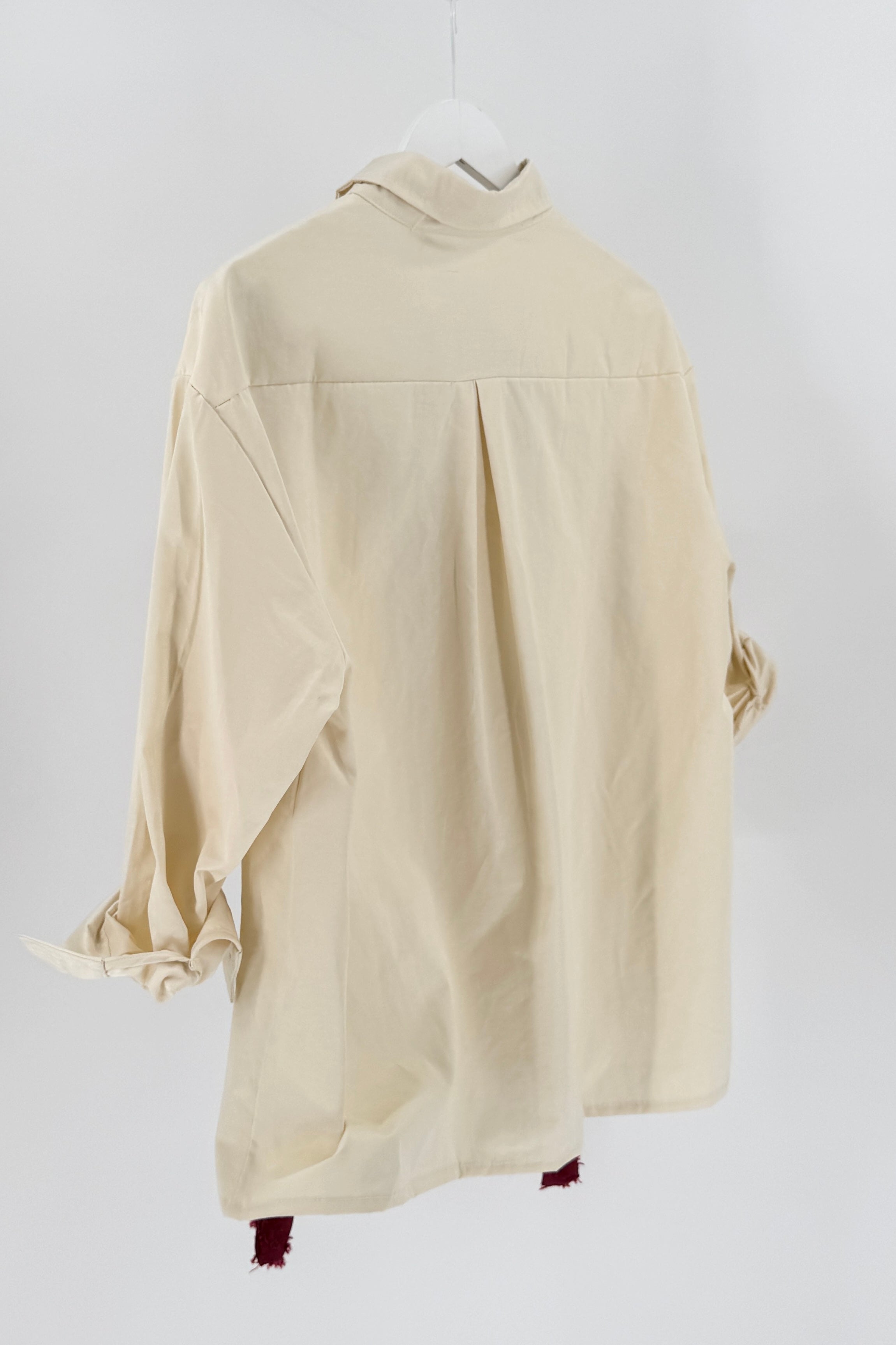 Beige shirt on a hanger against a white background