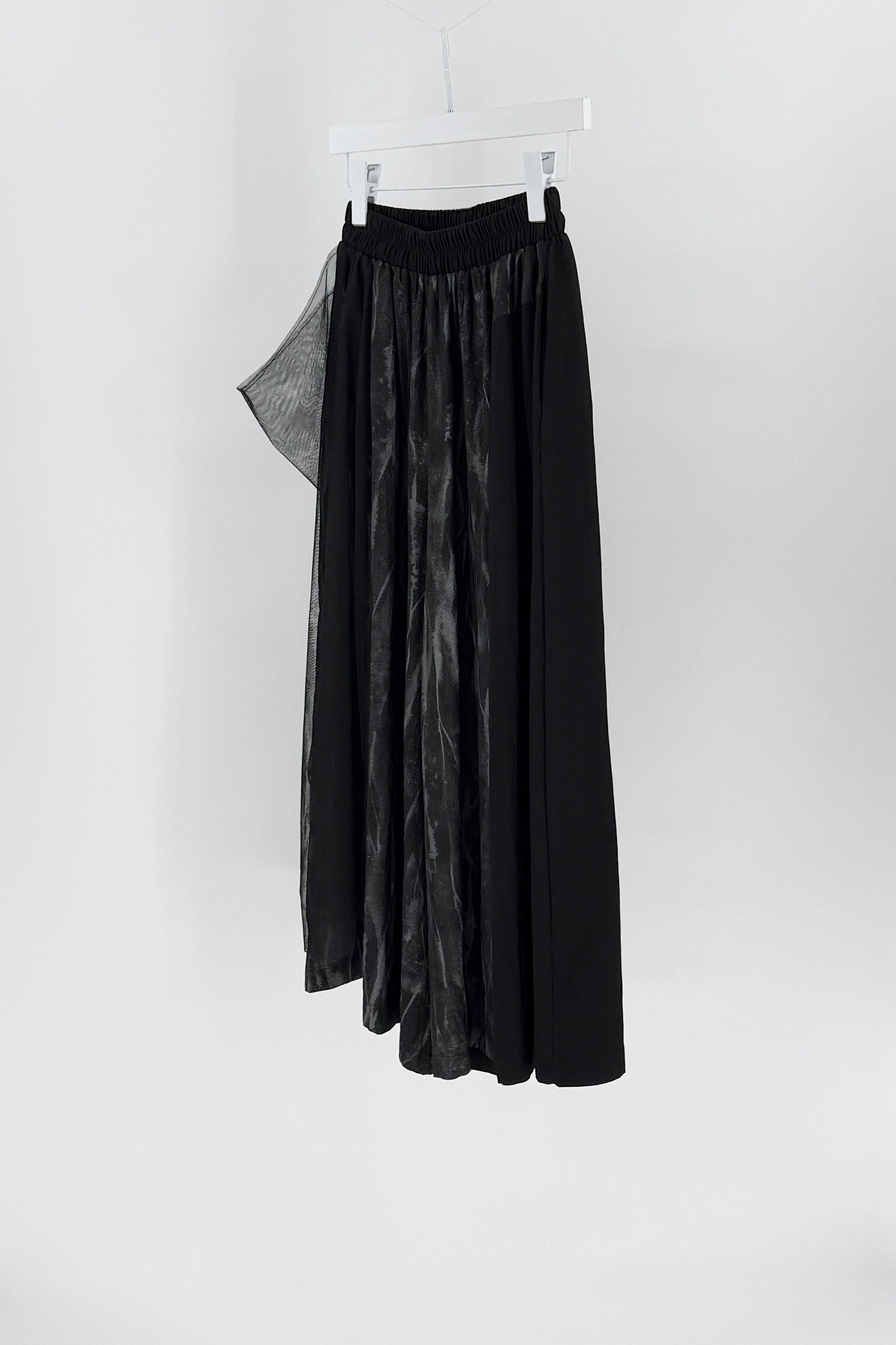 Black skirt hanging on a white background