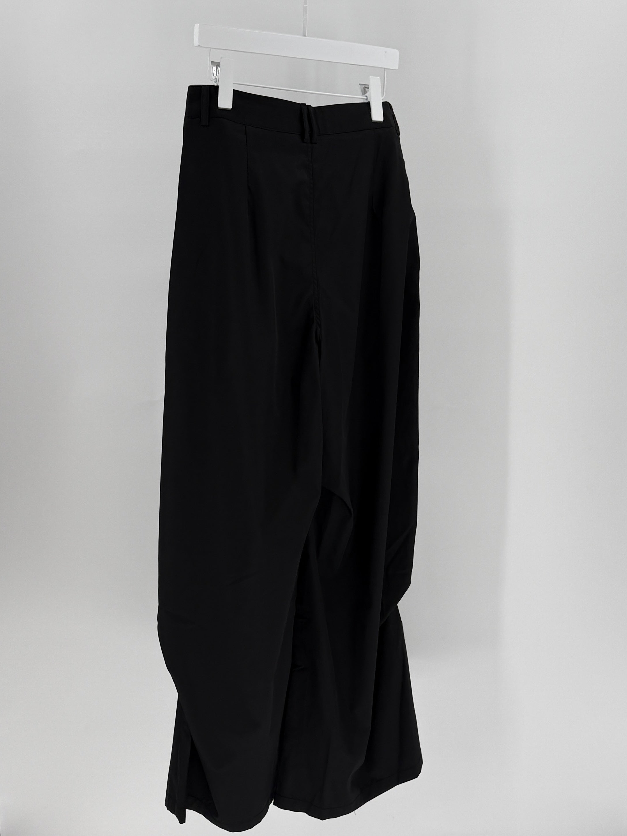 Black pants on a hanger against a white background