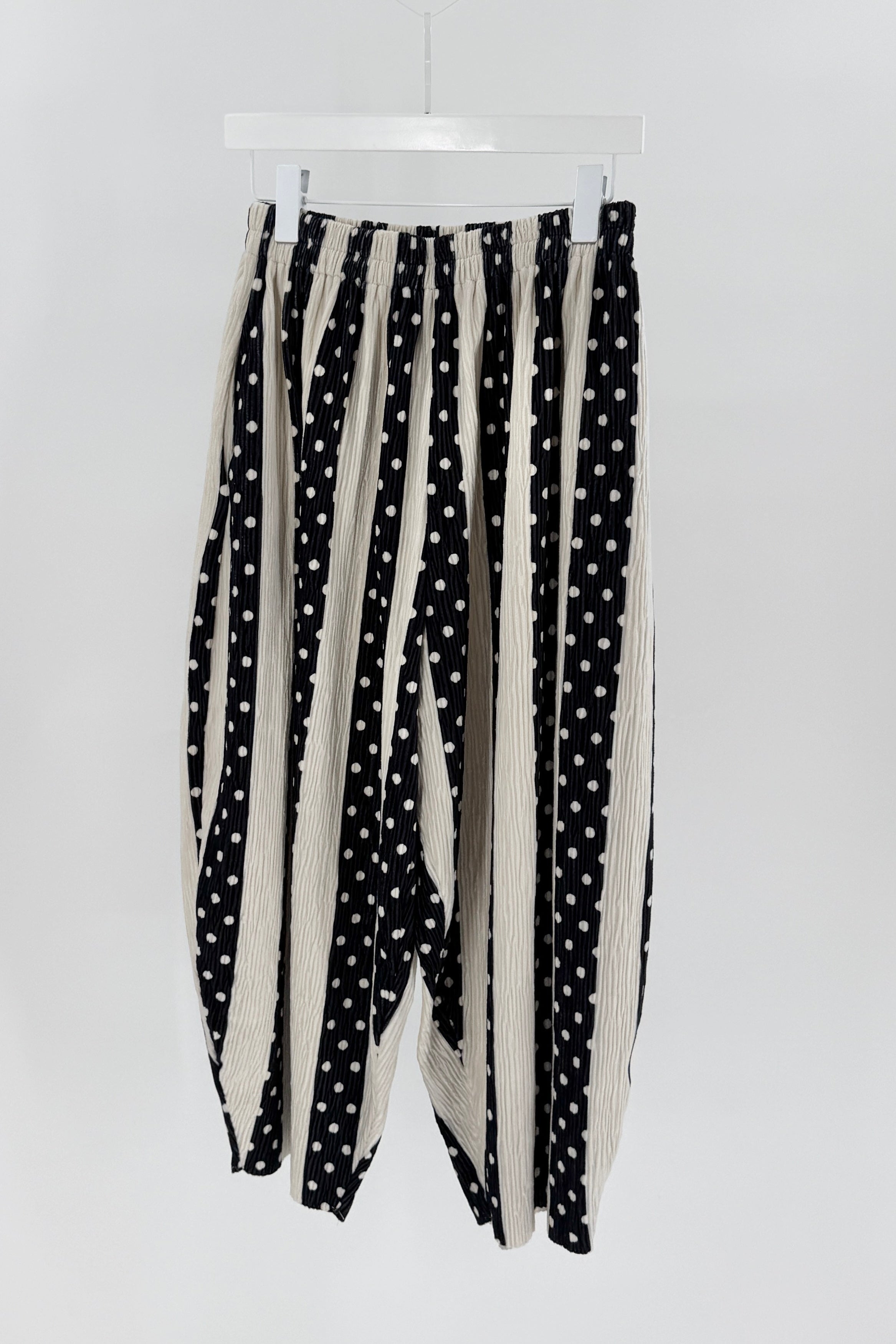 Black and white polka dot pants on a white background