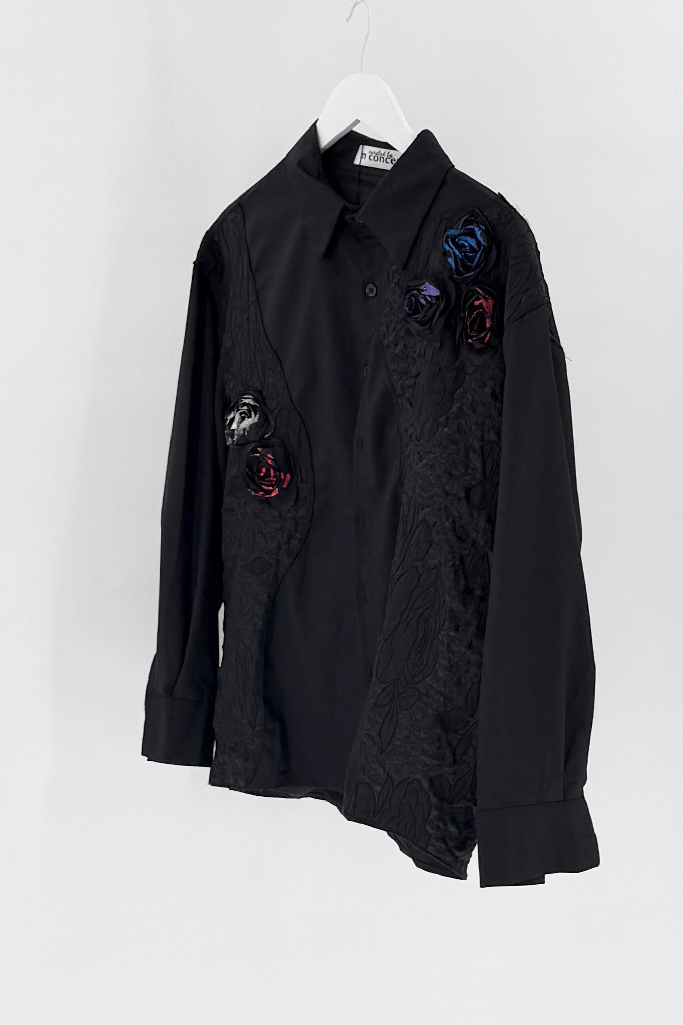 Black shirt with floral embellishments on a white background