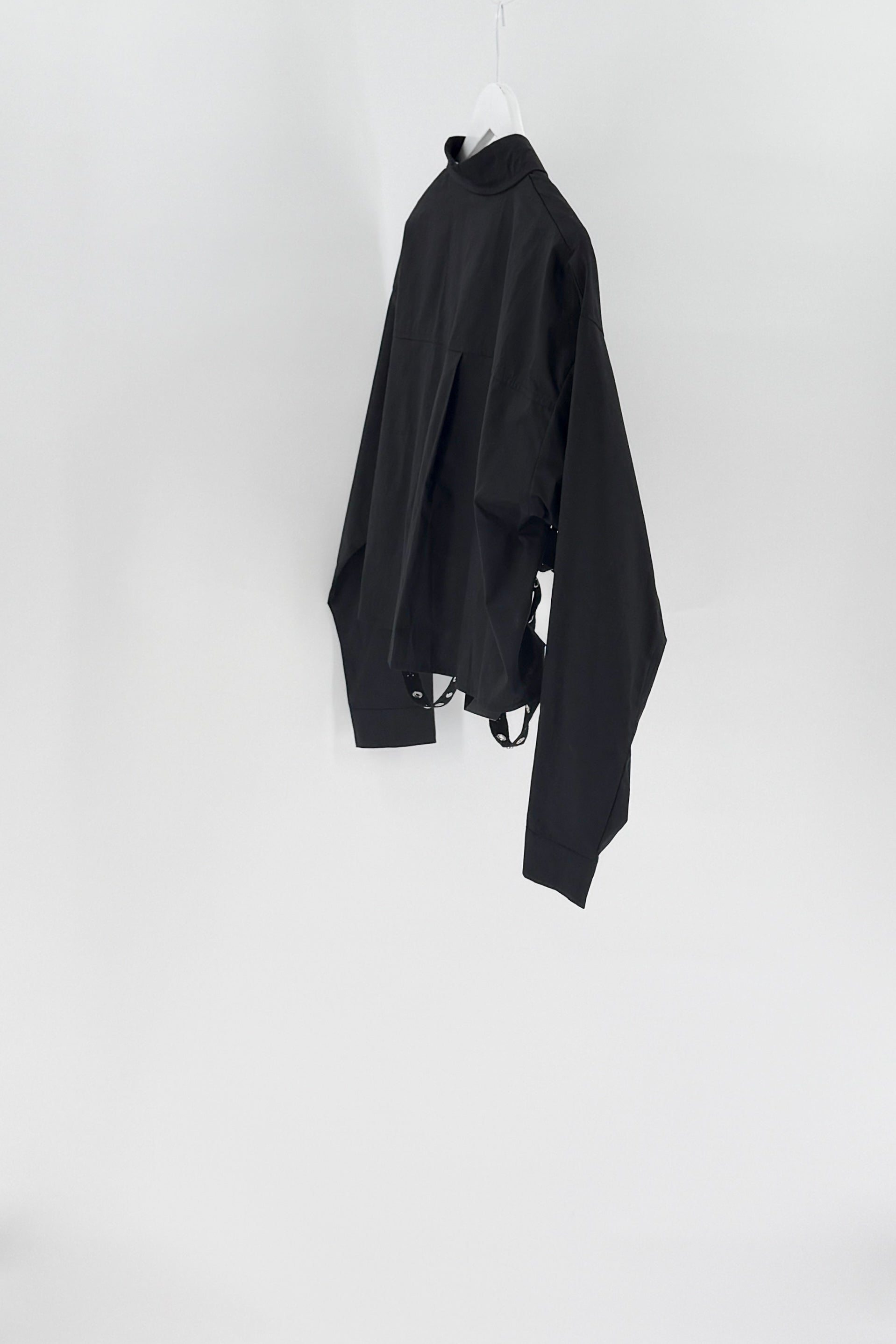 Black long-sleeve shirt on a white hanger against a white background