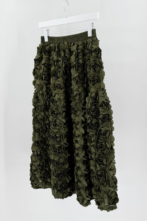 Green floral skirt on a white hanger against a white background
