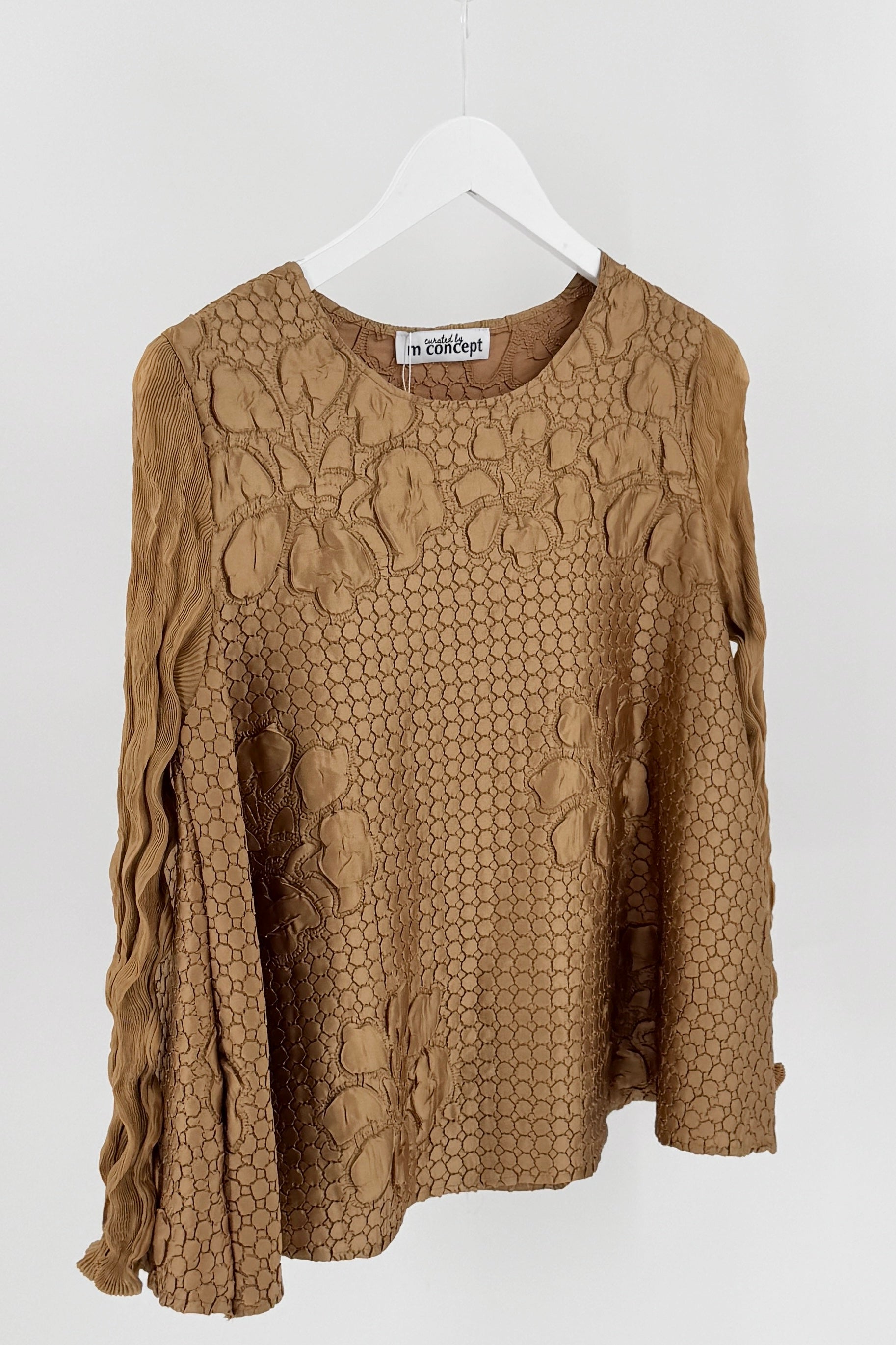 Brown textured blouse on a hanger against a white background