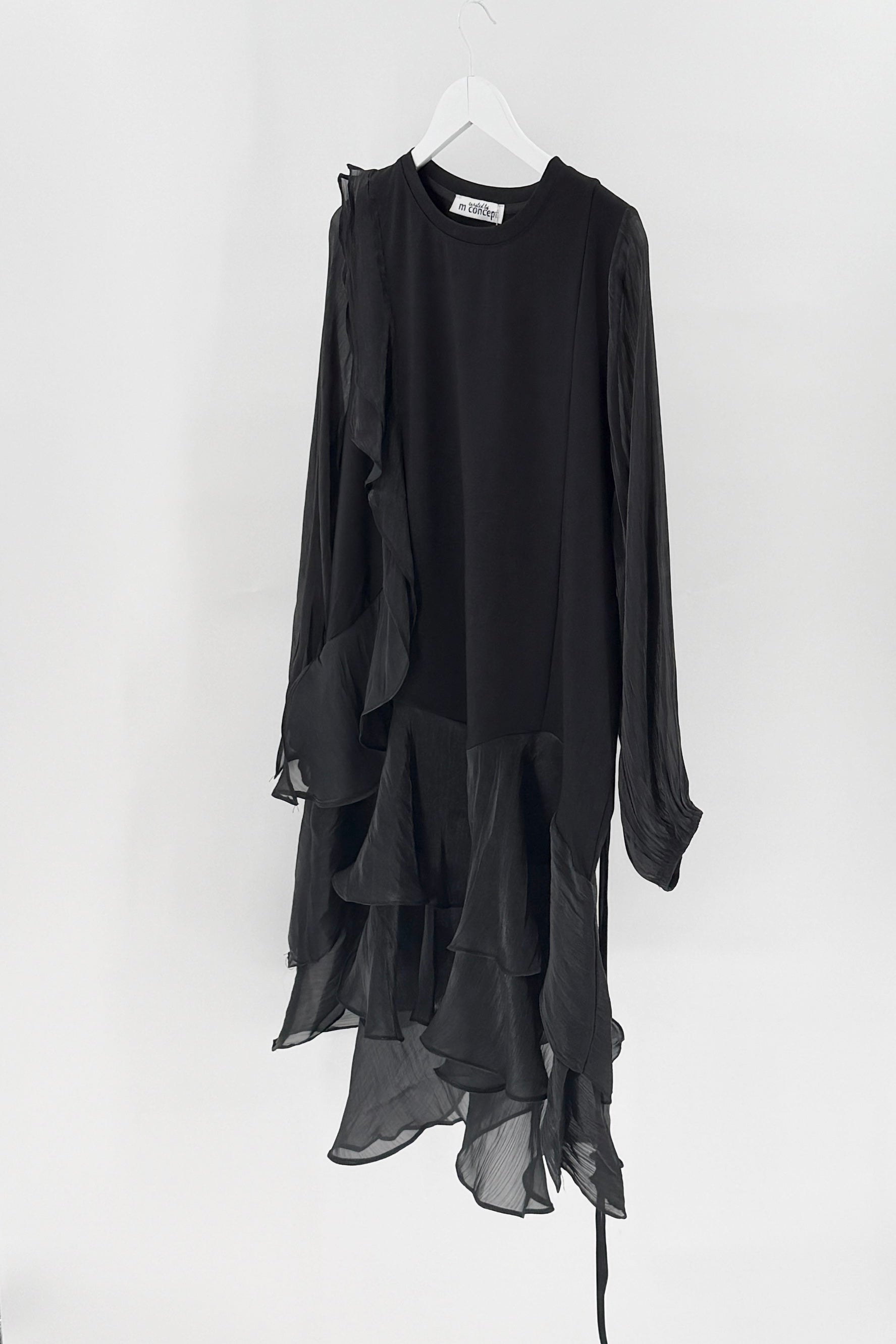 Black dress with sheer overlay on a white hanger against a white background