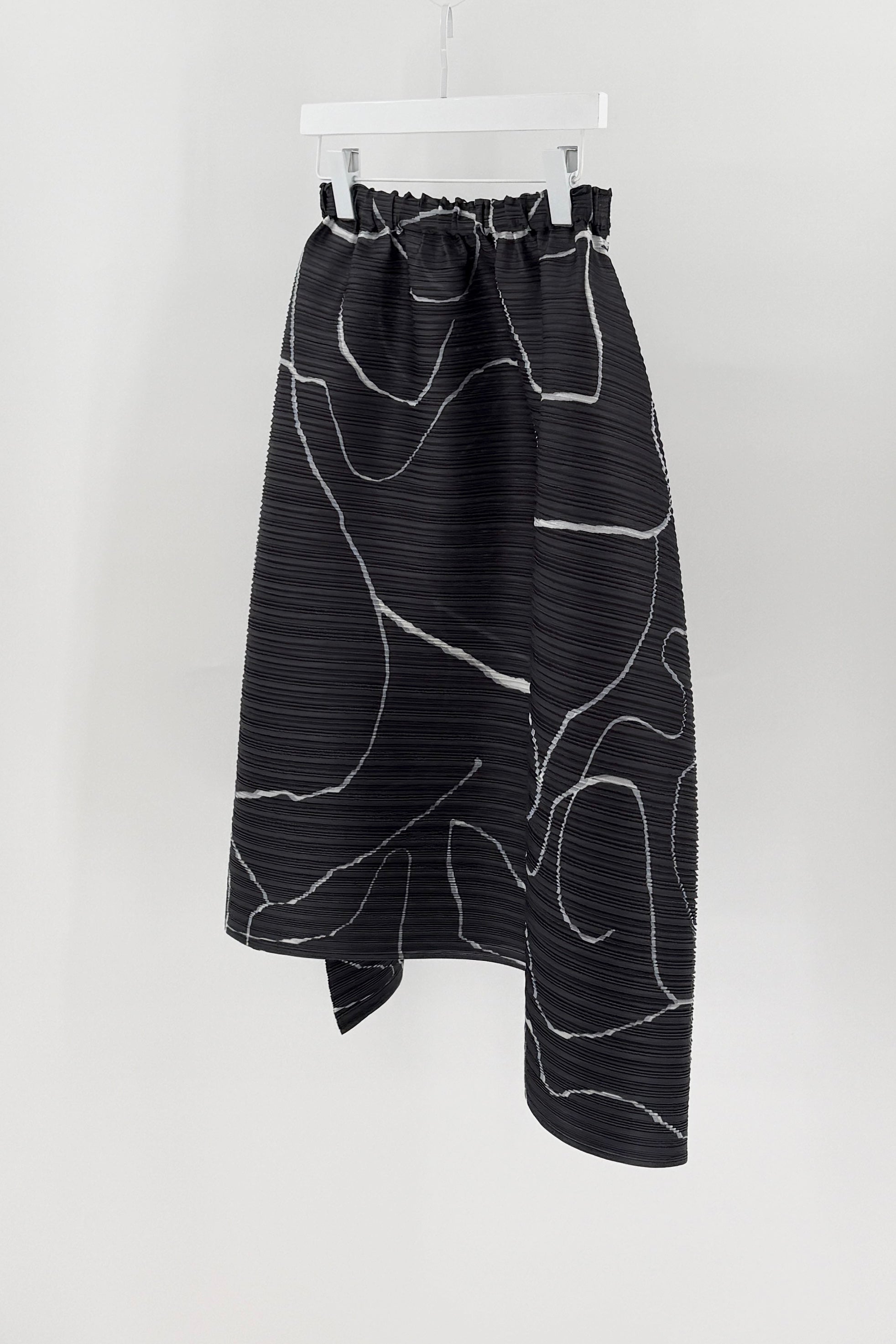 Black and white patterned skirt on a hanger against a white background