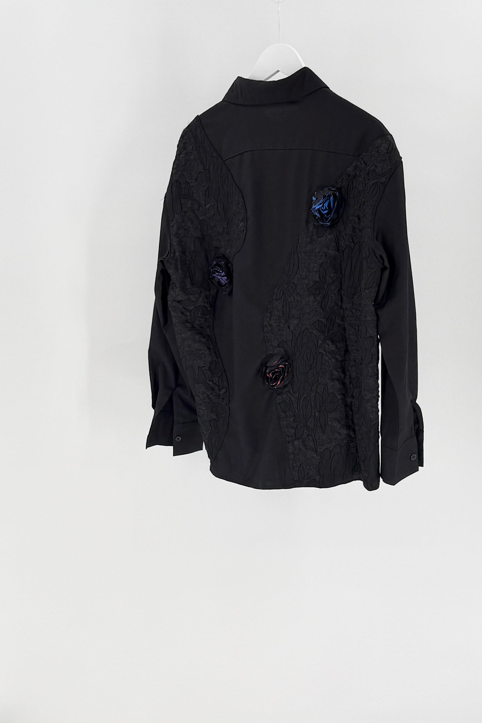 Black jacket with floral embellishments on a white background