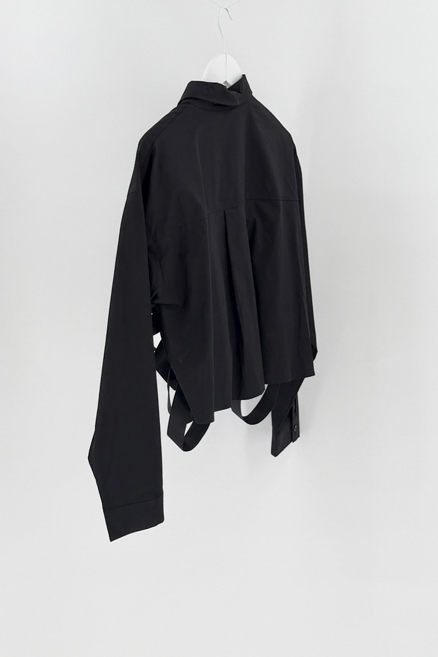 Black top on a white hanger against a white background