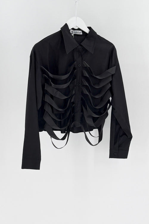 Black ruffled blouse on a white hanger against a white background