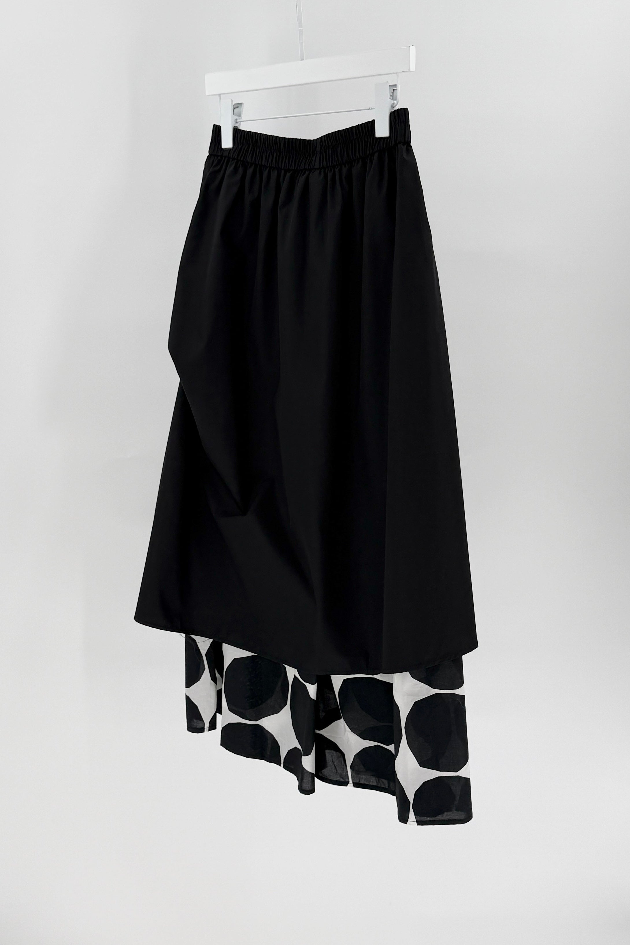 Black skirt pants combo with a patterned hem on a white background