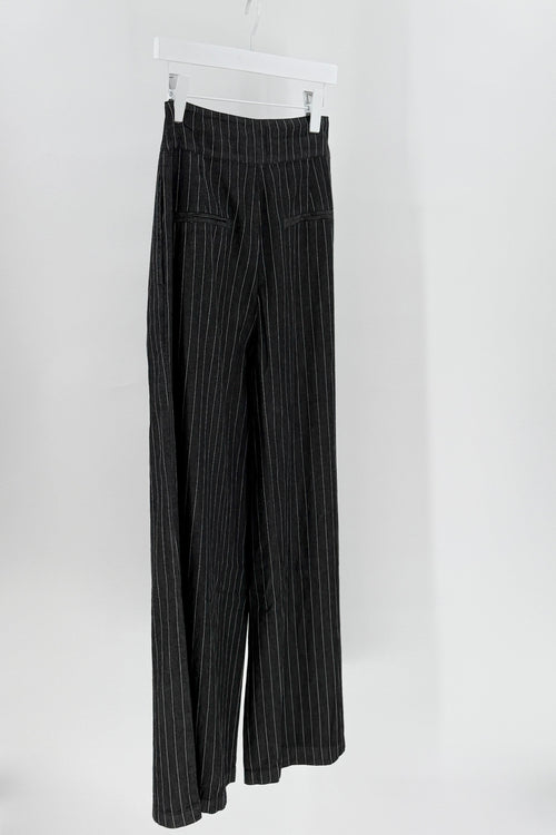 Black pinstripe pants on a white hanger against a white background