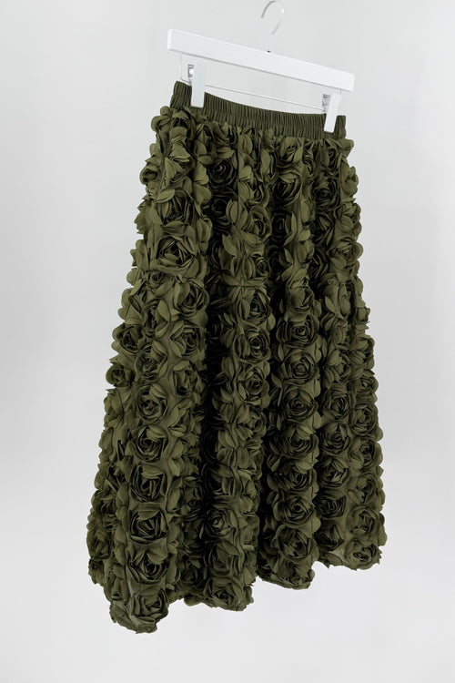 Green floral skirt on a white hanger against a white background