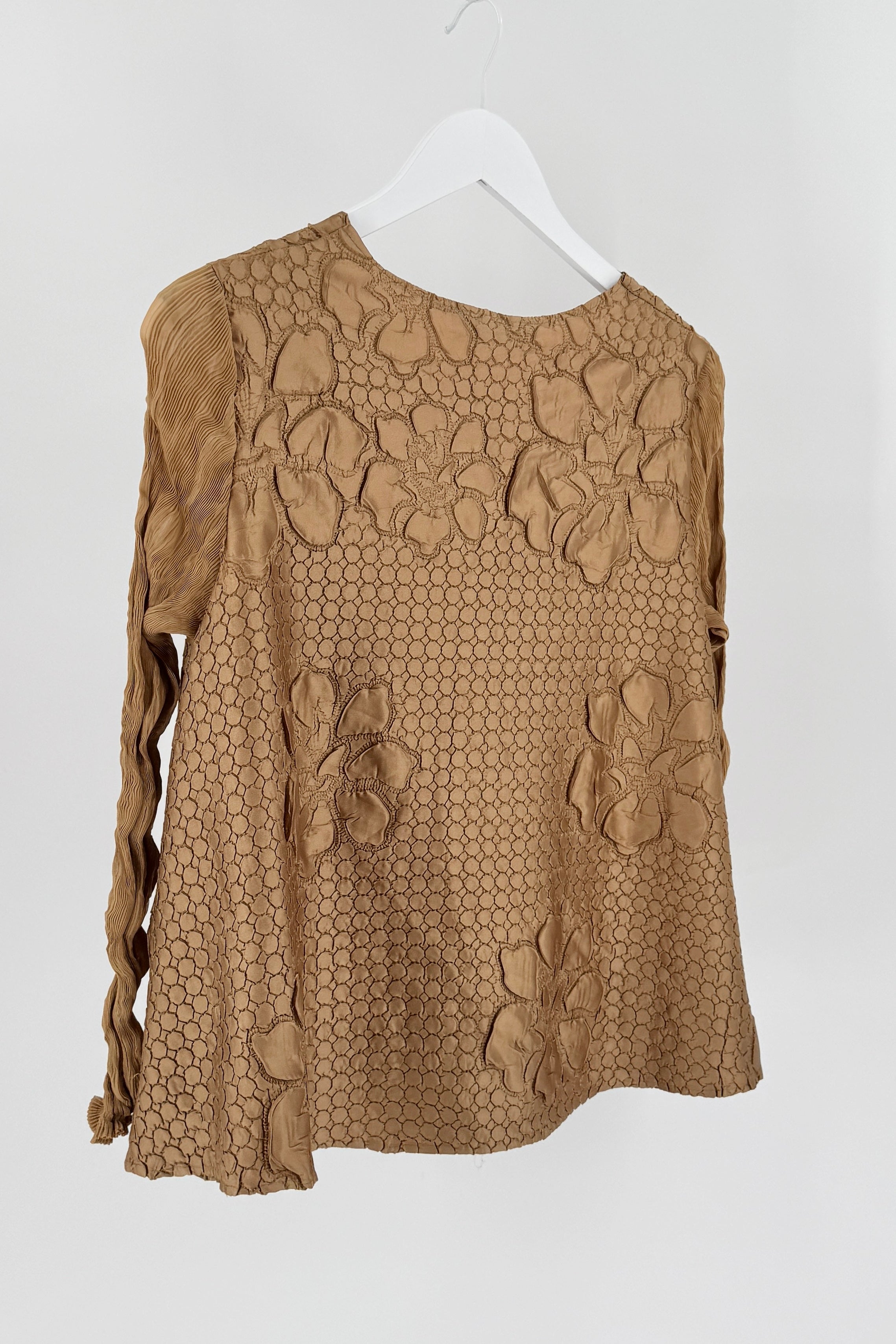 Brown lace top on a white hanger against a white background