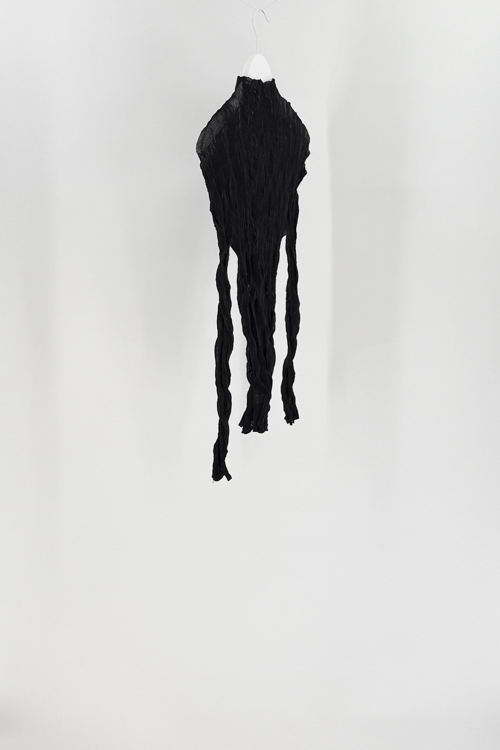 Black textured dress on a mannequin against a white background