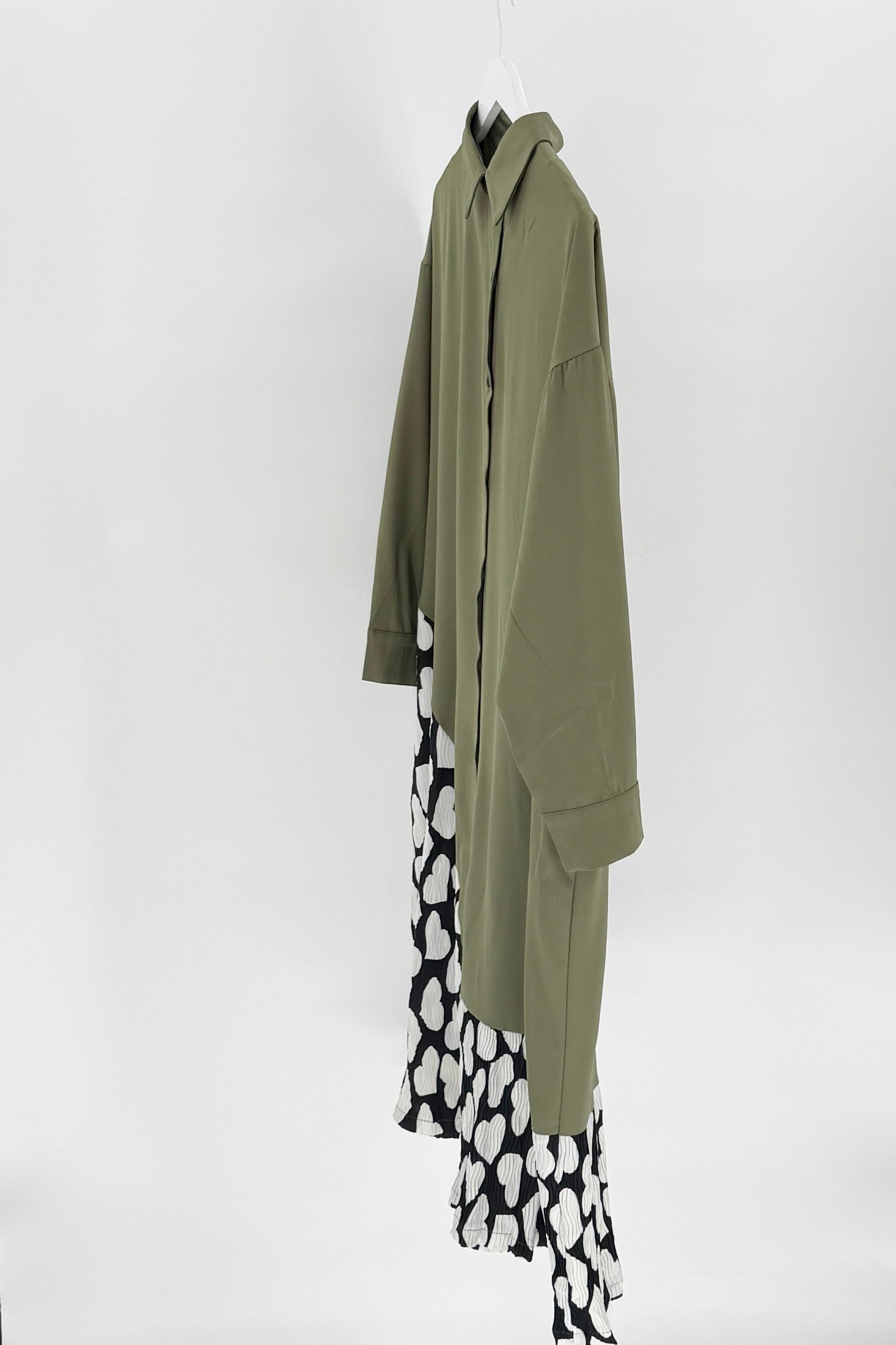 Green coat with a black and white patterned skirt on a white background