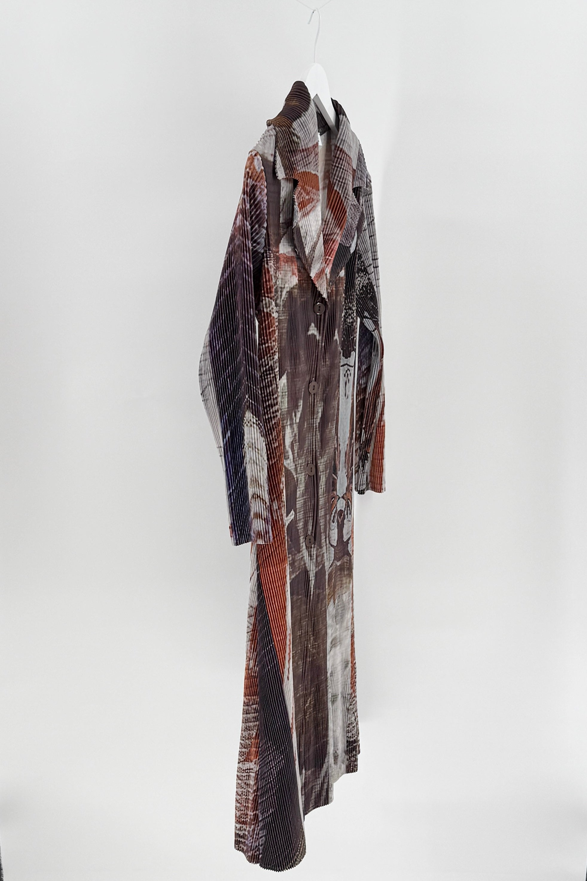 Long, patterned coat hanging on a white background