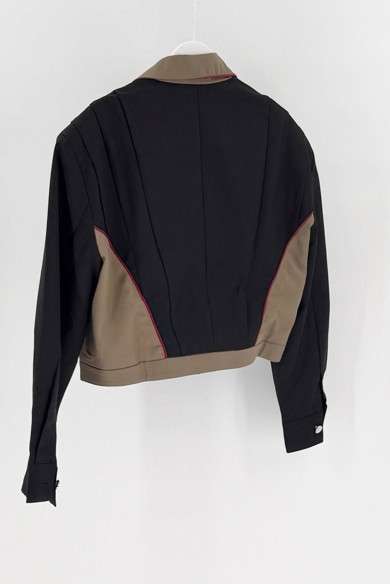 Black jacket with beige accents on a white background