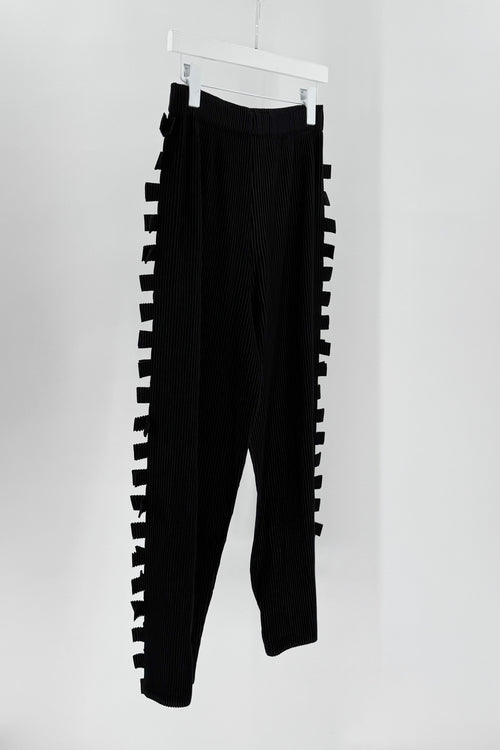 Black pants with unique cut-out design on a white background