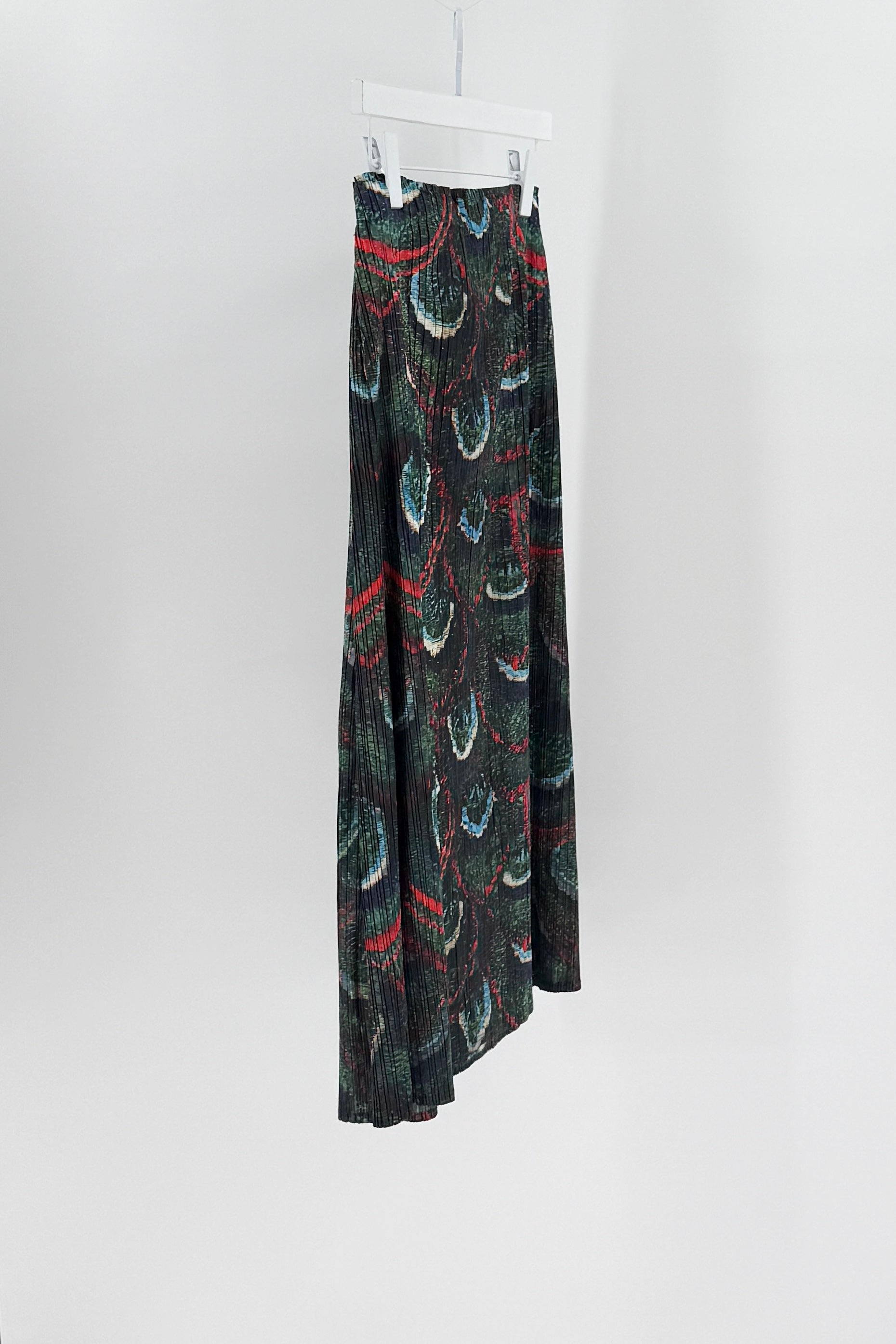Long patterned skirt hanging on a white hanger against a white background
