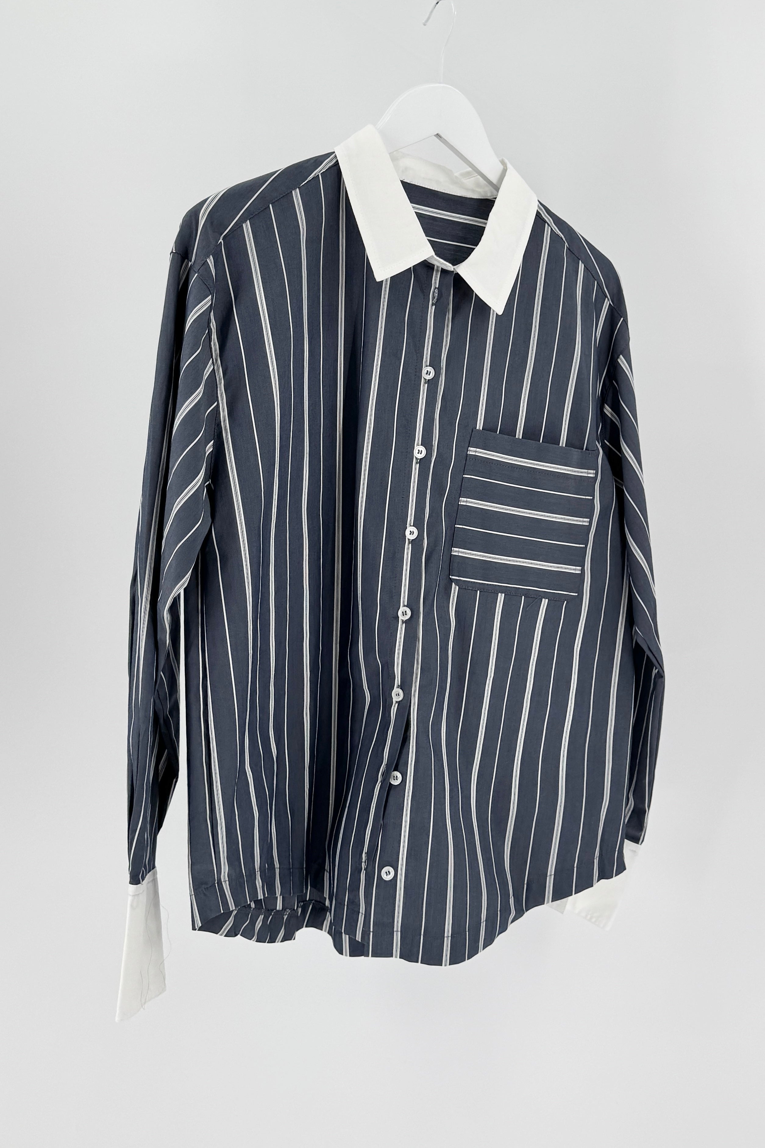 Striped shirt with a collar on a hanger against a white background